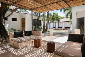 un patio al aire libre con sofás y una mesa en Aalada Playa del Carmen, en Playa del Carmen