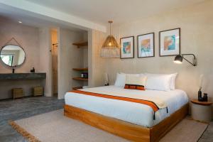 a bedroom with a large bed and a mirror at Aalada Playa del Carmen in Playa del Carmen