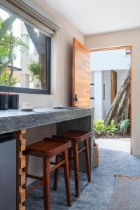 eine Küche mit Holzhockern und einer Theke mit einem Fenster in der Unterkunft Aalada Playa del Carmen in Playa del Carmen