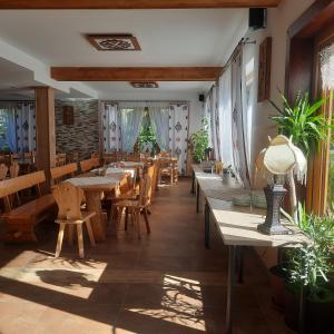 a restaurant with wooden tables and chairs and plants at Willa Grand Krzesanica in Kościelisko