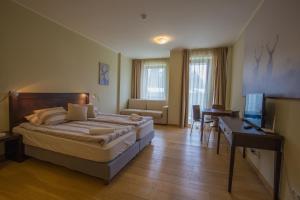 a bedroom with a bed and a desk and a television at Euphoria Club and Resort Rental in Bŭrduche