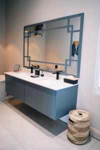 een badkamer met een wastafel met een grote spiegel bij The Oyster Box Beach House by The Oyster Collection in Kenton on Sea
