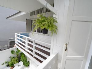 uma escada branca com plantas ao lado de uma porta em RoomQuest Rim Praya Dinsor Road em Bangkok