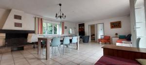 a living room with a fireplace and a table and chairs at La Ginelle - Appartement Isba in Airoux +8 photos