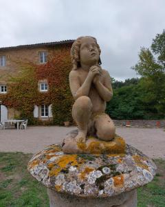 a statue of a little girl sitting on a rock at La Ginelle - Appartement Isba in Airoux
