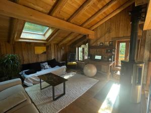 een woonkamer met een bank en een tafel bij Magnifique chalet dans la vallée de Chamonix in Servoz