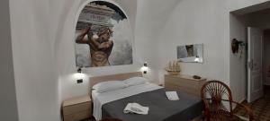 a bedroom with a bed and a painting on the wall at Terra d'Amuri Hotel in Catania