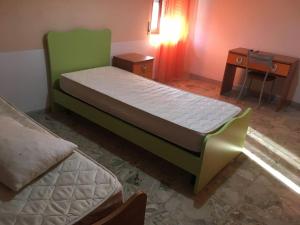 ein Bett in einem Zimmer mit einem Nachttisch und einem Bett sidx sidx sidx sidx sidx sidx in der Unterkunft Appartamento relax a Catanzaro Lido in Catanzaro