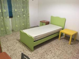 ein Schlafzimmer mit einem grünen Bett und einem Tisch in der Unterkunft Appartamento relax a Catanzaro Lido in Catanzaro