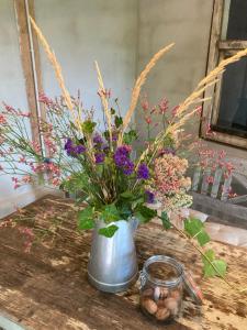wazon wypełniony kwiatami na stole w obiekcie Gut Kalkhäuschen, ein Ort mit Geschichte w Akwizgranie