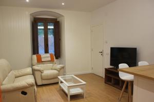 a living room with a couch a chair and a television at Apartamentos CAN GUSI in Ribes de Freser