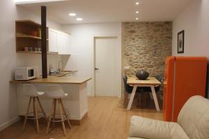 una pequeña cocina con encimera y mesa en Apartamentos CAN GUSI, en Ribes de Freser