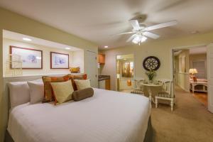 a bedroom with a white bed and a ceiling fan at Holiday Inn Club Vacations Holiday Hills Resort at Branson in Branson +48 photos