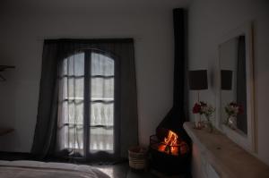 a bedroom with a bed and a window and a fireplace at Pousada Ilumina in São Francisco Xavier