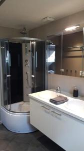 a bathroom with a shower and two sinks and a tub at Terrasses de Malmedy - Duplex 455 in Malmedy