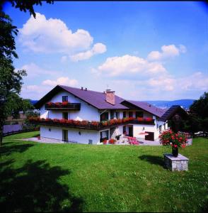 uma grande casa branca com flores num quintal em Hotel Bergwiesen em Lohr