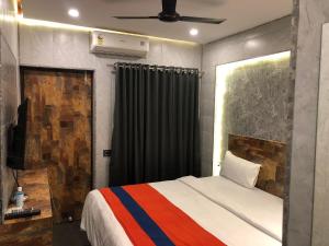 a bedroom with a bed and a ceiling fan at Aariv Inn in Baga