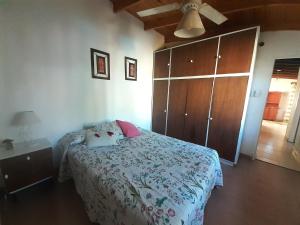 a bedroom with a bed and a wooden cabinet at Zorzales in Funes