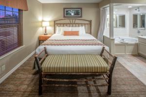 a bedroom with a bed and a bench with a tub at Holiday Inn Club Vacations Holiday Hills Resort at Branson an IHG Hotel in Branson