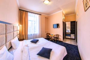 a hotel room with a white bed with blue pillows at Vanadzor Armenia Health Resort & Hotel in Vanadzor