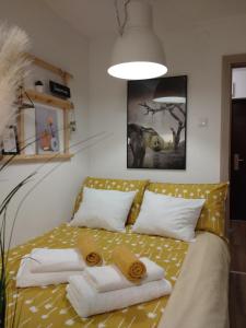 1 dormitorio con 1 cama con toallas en Apartman 7th Heaven, en Zagreb