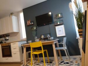a kitchen with a table and two yellow chairs at Apartman 7th Heaven in Zagreb
