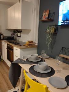 a kitchen with a table with plates and wine glasses at Apartman 7th Heaven in Zagreb