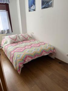 a bed with a colorful comforter in a bedroom at San Isidro Estación de Esqui in San Isidro