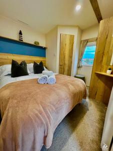 a bedroom with a large bed with two towels on it at Newquay Bay Resort - Summer Days 135 in Porth