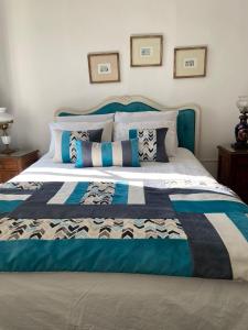 1 cama con edredón y almohadas azules y blancos en Casa Mackenna en Valparaíso