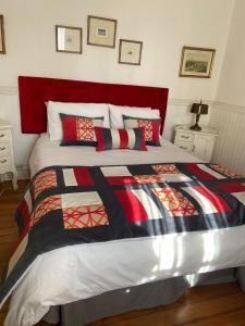 um quarto com uma cama grande e uma cabeceira vermelha em Casa Mackenna em Valparaíso