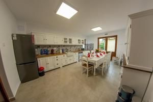 a large kitchen with a table and a refrigerator at Átalvetős Agropanzió in Morăreni