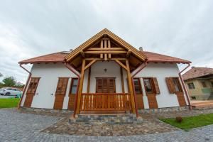 a small house with a wooden roof at Átalvetős Agropanzió in Morăreni +6 photos