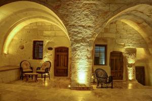 una habitación con sillas y una mesa en un edificio en Dionysos Cave Cappadocia Hotel, en Ürgüp