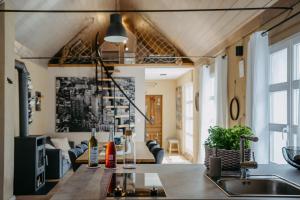 a kitchen with a sink and a living room at Wein Cottage Kellerstöckl in Eisenberg an der Pinka