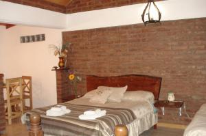 a bedroom with a bed and a brick wall at Cabañas Comarca del Colorado in Río Colorado