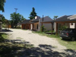 a house with a car parked next to a driveway at Cabañas Comarca del Colorado in Río Colorado
