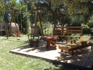 a picnic table and two benches and a swing at Cabañas Comarca del Colorado in Río Colorado +7 photos