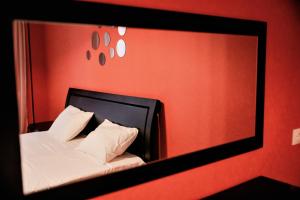 espejo que refleje una cama con sábanas y almohadas blancas en Avlabari Apartment - NEW ONE, en Tiflis