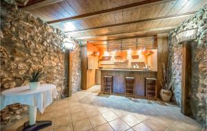 a kitchen with a table and a stone wall at Beautiful Home In Les Coves De Vinrom With Private Swimming Pool, Can Be Inside Or Outside in Les Coves de Vinroma
