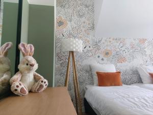 a bedroom with a bed and a stuffed rabbit on a desk at La touline in Concarneau +23 photos
