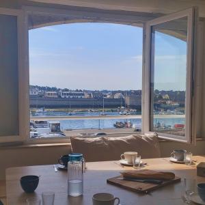 a table with a view of a harbor from a window at La touline in Concarneau