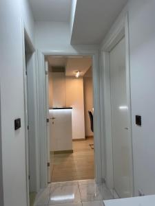 un pasillo con una puerta que conduce a una cocina en Luka Apartments Flatiron, en Skopje