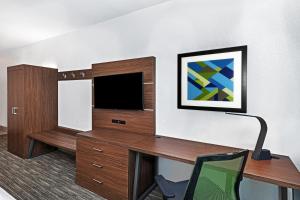 Habitación de hotel con escritorio y TV en Holiday Inn Express Hotel & Suites Lafayette South, an IHG Hotel en Lafayette