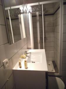 a bathroom with a sink and a mirror at Au Coup de Cœur in Colmar
