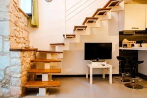 - un salon avec une télévision et des escaliers dans l'établissement Casa Basile, à Modica