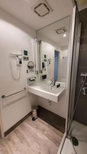 a white bathroom with a sink and a shower at Nice Apartment in modern Center of Düsseldorf in Düsseldorf