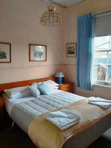 a bedroom with a large bed and a window at The Old Forge - an "Heritage' house in Fairlie