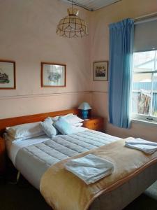 una camera da letto con un letto grande e una finestra di The Old Forge - an "Heritage' house a Fairlie