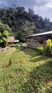 un edificio con un campo de hierba delante de él en Playa Selva Lodge, en Archidona